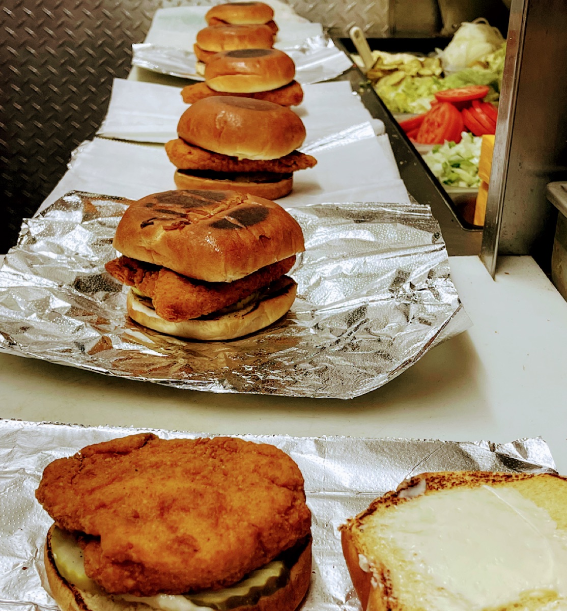 Fresh charbroiled chicken sandwiches and pitas on the line at Papa's